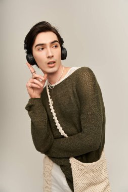 Modern bir stüdyoda müzik dinlerken genç ve şık olmayan kişi düşünceli bir şekilde poz verir..