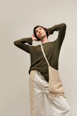 İkili olmayan genç bir kişi şık bir ortamda şık bir kıyafet sergiliyor..