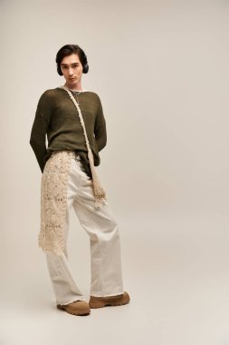 İkili olmayan genç bir kişi kendine güvenerek, canlı stil ve kimliğini moda yoluyla ifade eder..