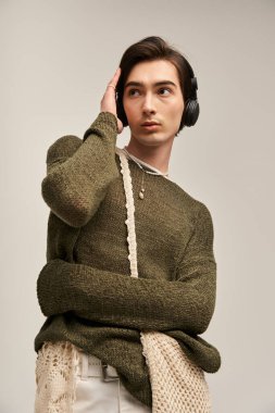Şık, genç, ikili olmayan bir birey müzik dinlerken eşsiz moda anlayışını sergiliyor..