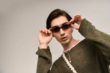 Şık, genç, ikili olmayan bir kişi kendine güvenen ve kendine hakim olan yaratıcı bir moda anlayışı sergiliyor..