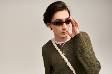 Şık, genç, ikili olmayan bir kişi kendine güvenen, eşsiz bir moda ve aksesuar sergileyen biri..