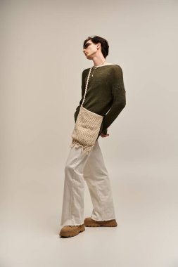 Kendine güveni olmayan biri şık bir stüdyo arkaplanına şık bir şekilde poz verir..