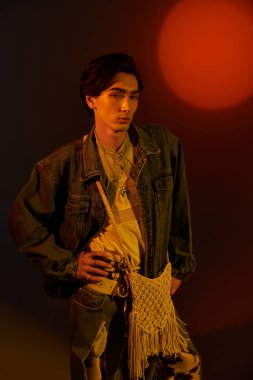 İkili olmayan şık bir insan sanatsal bir mekanda sıcak ışıkların altında parlar..