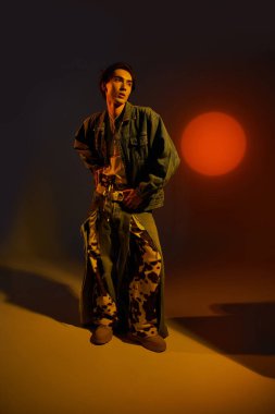 Genç ikili olmayan kişi çarpıcı bir günbatımı atmosferinde moda sergiliyor.