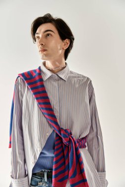 Şık, genç, ikili olmayan bir kişi kendine güvenerek, canlı moda tercihlerini sergiliyor..