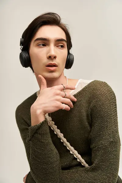 İkili olmayan bir genç, modaya uygun bir yerde müziğin tadını çıkarırken şık bir kıyafet giyer..