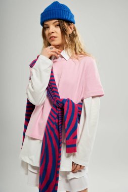 Mavi bereli güzel bir bayan stüdyoda şık bir kıyafet içinde poz veriyor..