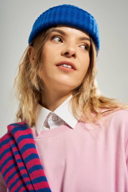 Mavi bereli güzel bir genç kadın şık bir kıyafet sergiliyor, kendine güven ve tarz yayıyor..