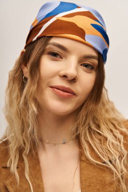 Güzel genç bir kadın moda anlayışını moda kıyafetleri ve renkli eşarplarıyla sergiliyor..