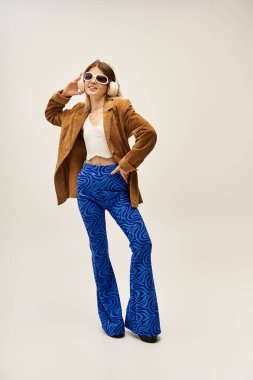 Kendine güvenen genç bir kadın şık bir elbiseyle poz verir. Bu onun canlı stilini ve moda anlayışını ön plana çıkarır..