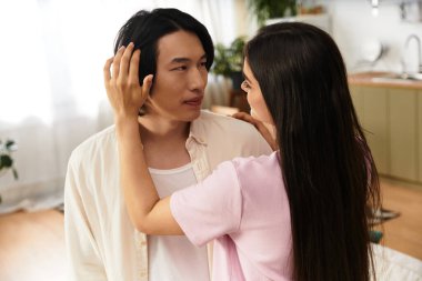 Bir erkek, bir kadına nazikçe dokunduğunda ona sevgiyle bakar. Sıcaklık odayı doldurur..