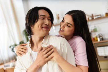 Neşeli bir çift, sevgi dolu bir şekilde evlerinde kucaklaşır. Yürek ısıtan bir bağ anından zevk alırlar..