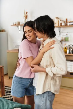 Bir çift eve davet ederken samimi bir şekilde kucaklaşır, sıcaklığı ve sevgiyi birlikte yayarlar..