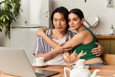 Sevgi dolu bir çift, birbirlerine sarılmış, neşeli bir video görüşmesi sırasında gülümsüyorlar.