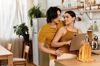 Bir çift, sıcak mutfaklarındaki tableti sevgiyle incelerken aynı kahkahayı paylaşıyor..