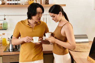 Bir erkek ve kadın, mutfaklarında kahve içerken sıcak bir anı paylaşıyorlar, sevgi saçıyorlar..