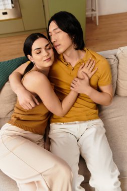 Bir çift rahat bir kanepede rahatlar, evlerinde sevgi ve sıcaklığı paylaşırlar..