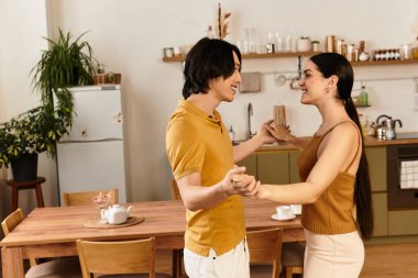 Neşeli çift, sevgi dolu mutfaklarında dans ederken hassas bir anı paylaşıyor..