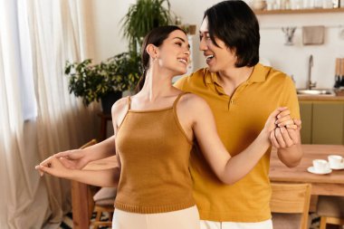 Mutlu bir çift sıcak ve davetkar evlerinde neşeyle dans ederken kucaklaşır..