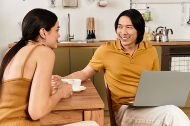 Bir çift, evde mutfaklarında dinlenirken eğlenceli sohbetlerden ve sıcak içeceklerden hoşlanır..