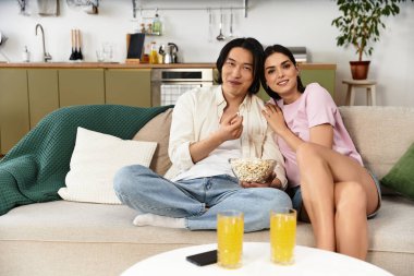 Sevgi dolu bir çift rahat bir koltukta oturur, patlamış mısır paylaşır ve rahatlarken içkinin tadını çıkarırlar..