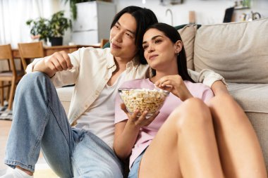 Evde iki insan bir film izlerken patlamış mısır ve kahkaha paylaşır..