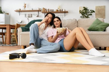 Çiftler romantik film gecelerini severler, patlamış mısırlarını paylaşırlar ve rahat yaşam alanlarında gülümserler..