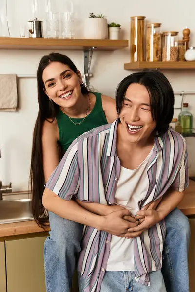 Mutlu bir çift, birbirlerine eşlik etmekten zevk alır. Davetkar mutfaklarında gülüp kucaklaşırlar..