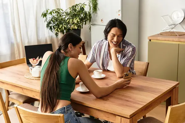 Bir çift evde kahve yudumlarken birlikte eğleniyor, gülümsüyor ve gülüyor..