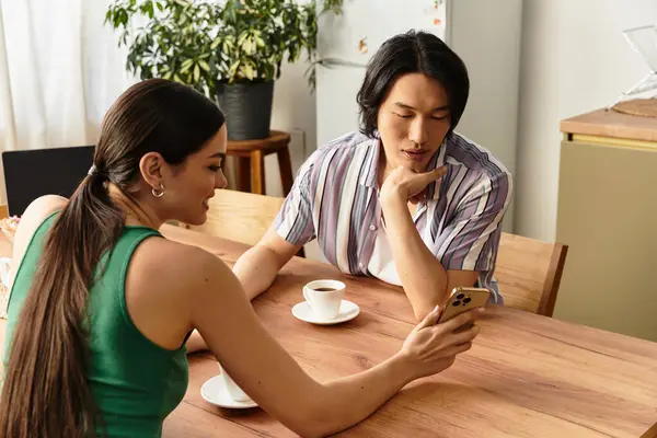 Sevgi dolu ortaklar kahvenin tadını çıkarırken telefonlarından bir şeyler izlerler..