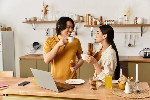 Affectionate couple shares laughter and food in a bright kitchen, creating memories together.