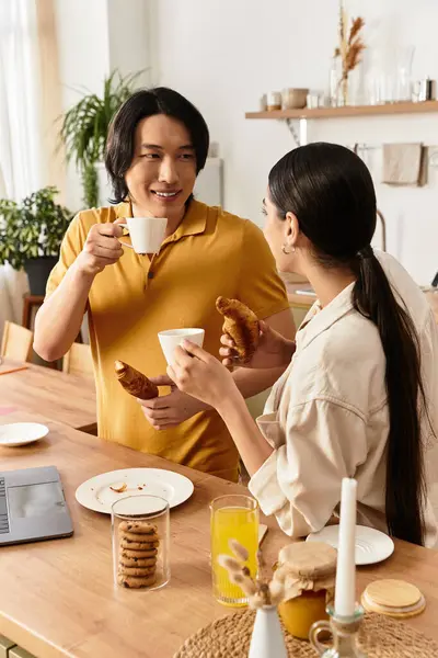 Sevgi dolu bir çift, keyifli mutfaklarında kahve ve kruvasan içerken samimi anlar paylaşır..