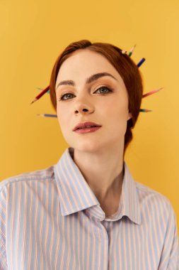 Kendine güvenen genç bir kadın eşsiz kalemle süslenmiş saç stilini sergiliyor..