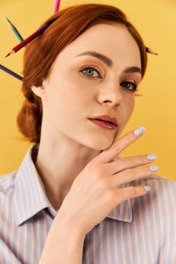 Genç bir kadın yaratıcılığını saçlarında kalemlerle sergiliyor..