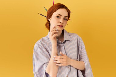 Genç bir kadın zarif poz veriyor, sanatını saçlarında renkli kalemlerle sergiliyor..