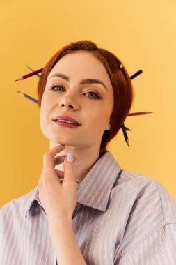 Parlak renkli arka plan, kalemi olan şık bir genç kadının sanatsal ifadesini geliştirir..