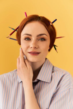 Genç bir kadın renkli kalemlerle vurgulanmış, neşeli bir saç stili sergiliyor..