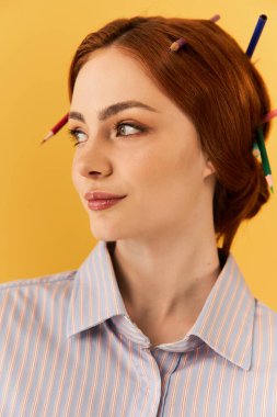 Kendine güvenen genç bir kadın eşsiz saç stilini renkli kalemlerle süslüyor..