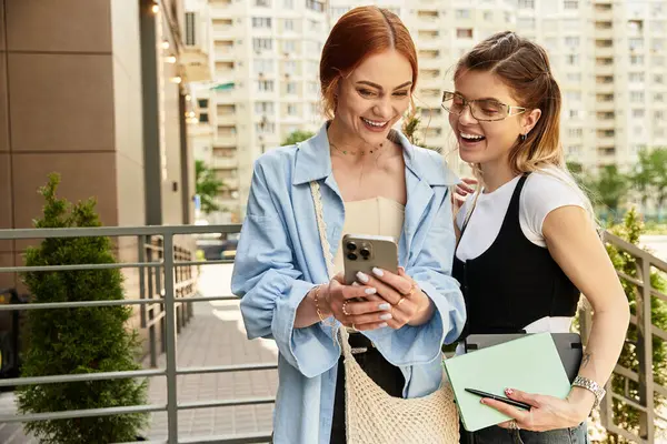 İki şık genç kadın şehirde eğlenceli anlar paylaşırken mutlu bir şekilde sohbet ediyorlar..