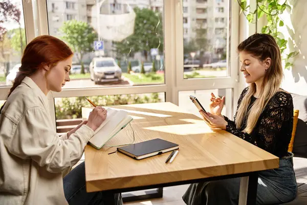 İki genç kadın şık bir kafede derslerine odaklanır ve birbirlerine eşlik ederler..