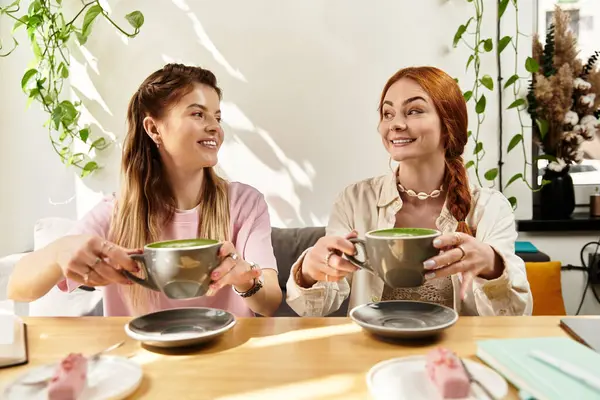 İki genç kadın, şık bir kafede içki içerken birbirlerine eşlik etmekten zevk alırlar..