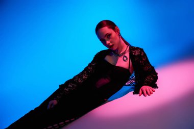 Güzel bir genç kadın moda anlayışını çarpıcı bir stüdyoda sergiliyor..