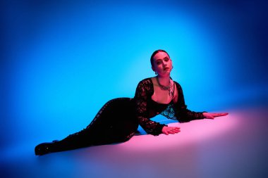 Güzel genç bir kadın zarif bir şekilde poz veriyor. Stüdyoda büyüleyici bir ışık var..