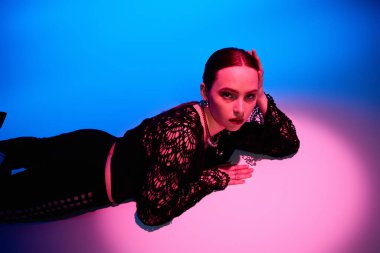 Güzel genç bir kadın moda anlayışını canlı ışıklandırmalı bir stüdyoda sergiliyor..