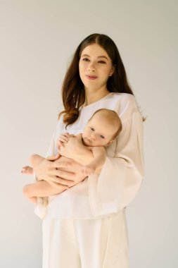 Sadık, genç bir anne, bebeğini kucaklar. Huzurlu bir ortamda sıcaklığını ve sevgisini yayar..