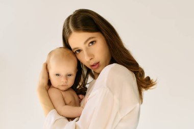 Genç anne sevgi dolu bir şekilde bebeğini kucaklar, erken yaşta anne olduğu anları gösterir..