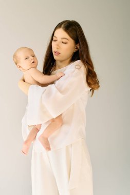 Genç bir anne çocuğuna sevgiyle bakar, ebeveynliğin sıcaklığını somutlaştırır..