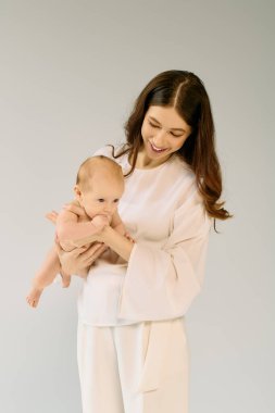 Genç bir anne, melez çocuğunu yumuşak, rahat bir ortamda tutarken mutluluk saçar..