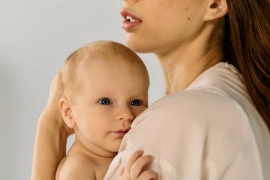 Genç bir anne sevgiyle çocuğunu kucağına alır, sıcak, sevgi dolu bağlarını gösterir..